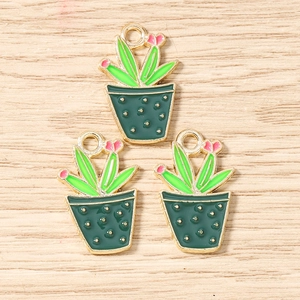 Detailed view of three green cactus enamel charms with pink flowers and gold alloy rings