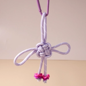 Detail of purple woven knot keychain featuring pink star beads and a matching carabiner hook