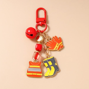 Close-up of firefighting charms including protective vest, gloves, and boots on a keychain