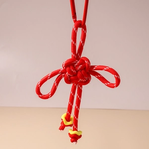 Detail of red handmade Chinese knot keychain with paracord texture and metal carabiner