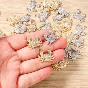 Gros plan de pendentifs crabe dorés et argentés avec strass pour création de bijoux