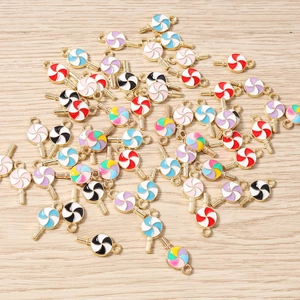 Gros plan de breloques sucettes colorées en émail avec anneaux pour création de bijoux