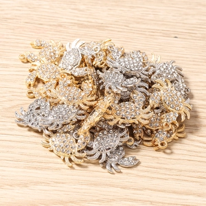 Détails macro de breloques crabe en strass pour bijoux DIY en finitions or et argent