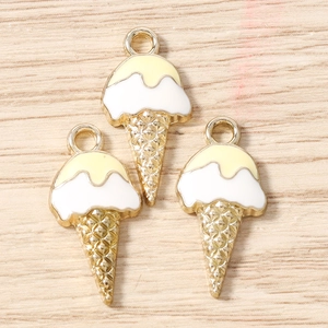 Vue macro de trois breloques de crème glacée émaillée dorée pour bijoux DIY