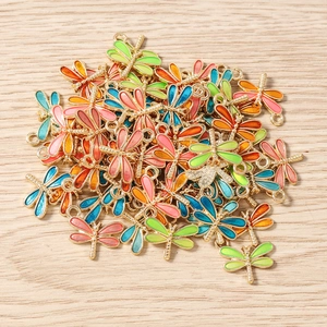 Gros plan de pendentifs libellule en émail coloré et métal doré pour bijoux DIY créatifs