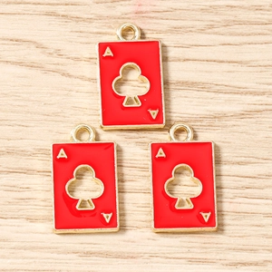 Macro shot of gold-plated Ace of Clubs playing card pendants with red enamel finish