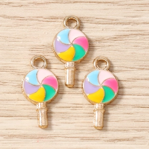 Détail macro de trois pendentifs sucettes en émail coloré avec bords en alliage d'or pour bijoux
