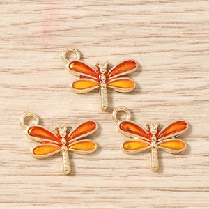 Détail de trois pendentifs libellules dorés avec émail orange pour la création de bijoux