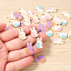Macro detail of colorful cartoon rabbit pendants with carrot for DIY jewelry making