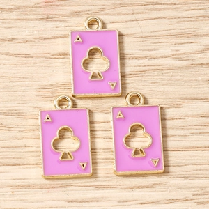 Close-up of three pink enamel Ace of Clubs charms with golden frames for jewelry making
