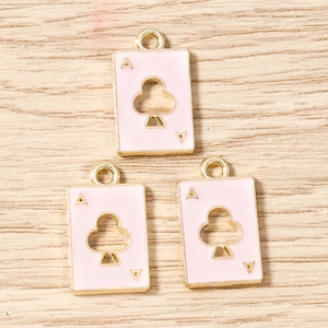 Macro view of pink enamel Ace of Clubs playing card pendants with gold metal frames
