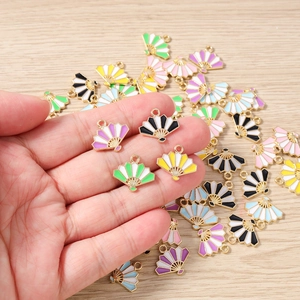 Macro detail of colorful enamel folding fan pendants with gold metal frames for DIY jewelry