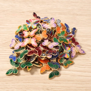 Macro detail of multi-colored enamel butterfly charms with threading holes for DIY jewelry