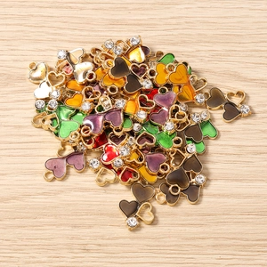 Colorful enamel heart pendants with rhinestones on a light wood background