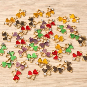 Macro view of colorful enamel heart charms with rhinestones on a wooden table
