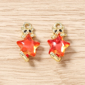 Détail de breloques chat doré avec étoiles rouges facettées pour bijoux