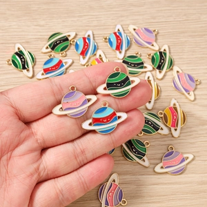 Macro detail of colorful Saturn oil drip alloy charms for DIY jewelry making and crafts