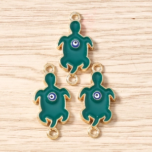 Detail of green turtle charms with evil eye inlay for DIY jewelry making and bracelets