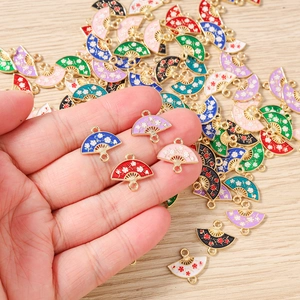 Detailed macro of cherry blossom enamel fan pendants with dual alloy rings for DIY jewelry