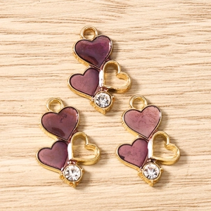 Detail of purple enamel heart charms with rhinestones and gold plating for jewelry DIY