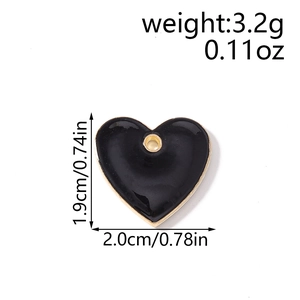 Detail showing dimensions and weight of a black heart pendant with gold alloy trim