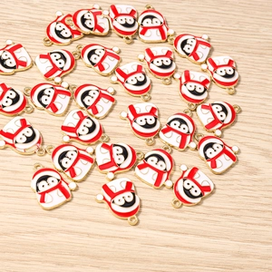 Flachbild von Pinguin-Anhängern mit roten Weihnachtsmützen für DIY-Schmuckherstellung