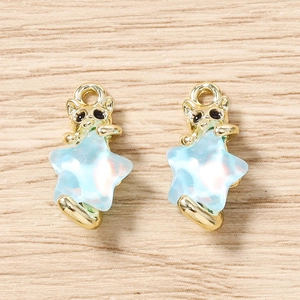 Vue détaillée de breloques chat doré et étoile bleue pour création de bijoux