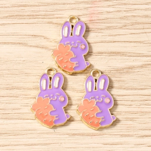 Detailed macro view of purple rabbit enamel charms for DIY jewelry and keychain making