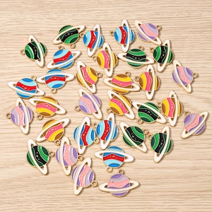 Detailed close-up of colorful enamel Saturn pendants with gold-plated alloy loops for DIY