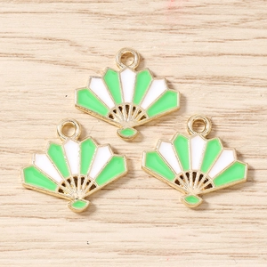 Detailed macro view of three fan-shaped enamel charms with green and white finish