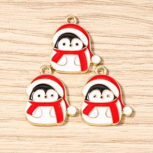 Detailansicht von drei Pinguin-Anhängern mit Weihnachtsmützen und Schals für DIY-Schmuck