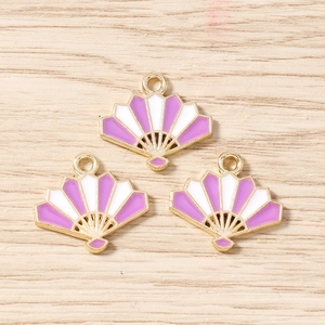Detailed macro view of three purple and white enamel folding fan pendants for DIY jewelry