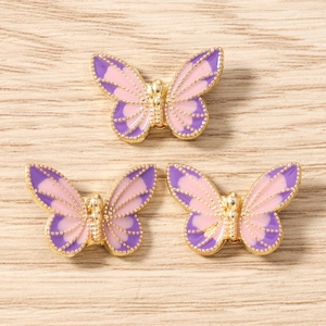 Detailed macro view of three butterfly enamel pendants for DIY jewelry crafting