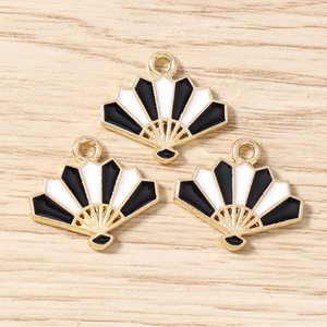Detail of three black and white fan-shaped enamel charms for DIY jewelry crafting