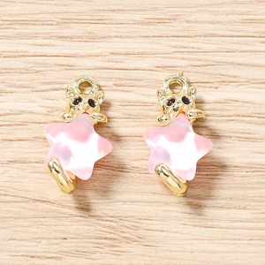 Vue détaillée de deux têtes de chat dorées avec pendentifs étoiles roses sur bois