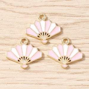 Flat lay of pink fan-shaped alloy pendants with gold plating for jewelry making