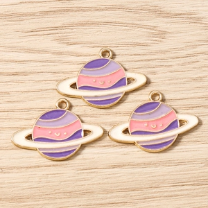 Detailed view of colorful Saturn charms with smiley faces for DIY jewelry making