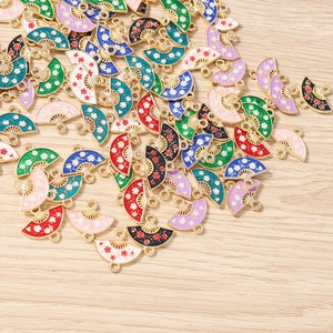 Macro shot of colorful enamel fan charms with floral patterns and gold metal edges