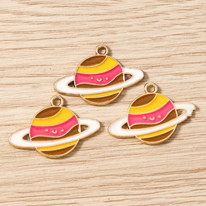 Close-up of planet enamel charms with smiley faces for DIY jewelry making