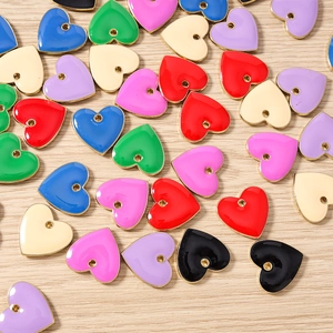 Macro detail of colorful enamel heart charms with gold metal edges for DIY jewelry crafts