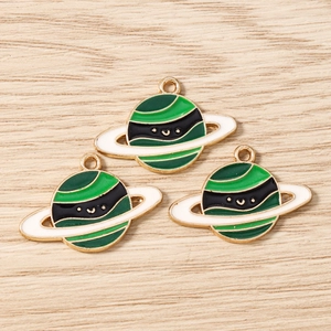 Detailed macro view of Saturn planet charms with colorful enamel finish and smiley faces