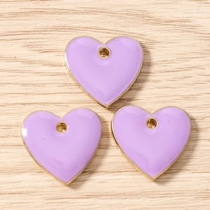 Close-up of lavender enamel heart charms with gold edges for jewelry making DIY