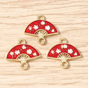 Detail of red fan-shaped enamel charms with white plum blossoms for DIY jewelry making