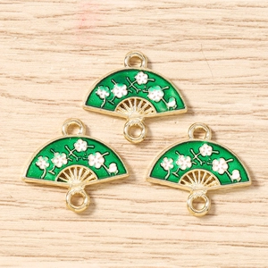Detail of green enamel fan-shaped jewelry charms with white plum blossom patterns