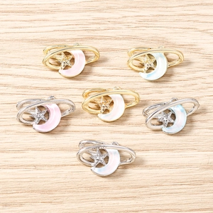 Vue détaillée de pendentifs étoile et lune avec incrustation irisée sur fond bois