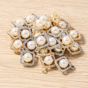 Macro detail of geometric square pendants with rhinestones and central pearls for jewelry making