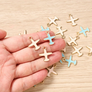Detalle de dijes de avión en miniatura esmaltados para joyería DIY en azul y blanco crema
