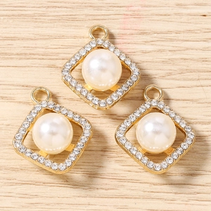 Macro view of three gold diamond geometric charms with pearls for DIY jewelry making