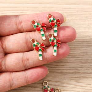 Macro view of Christmas candy cane pendants held by hand to show compact size