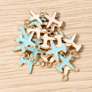 Detalle macro de colgantes de avión en esmalte azul y beige para accesorios de joyería DIY